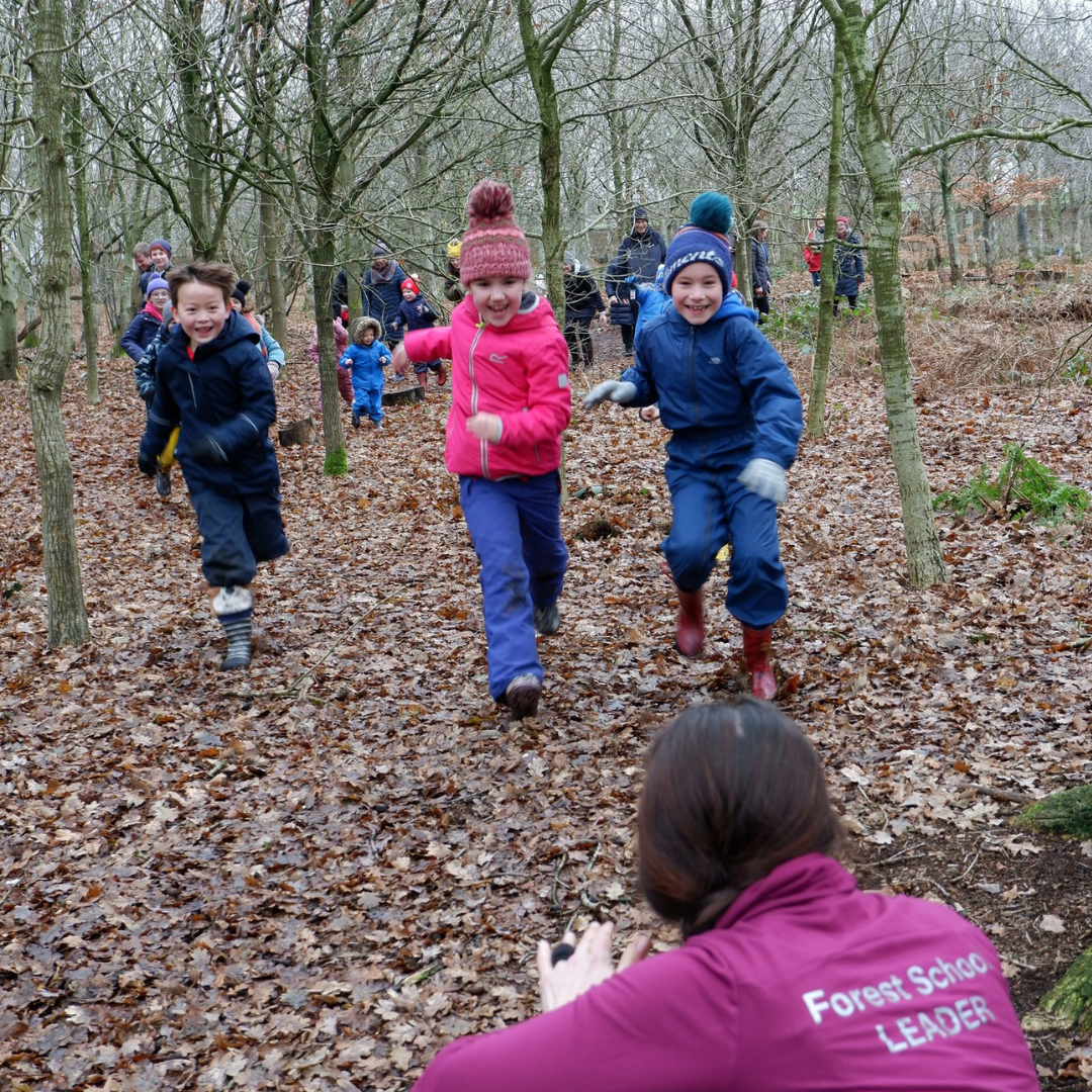 Communitree forest school leader playing drum game with a group of children