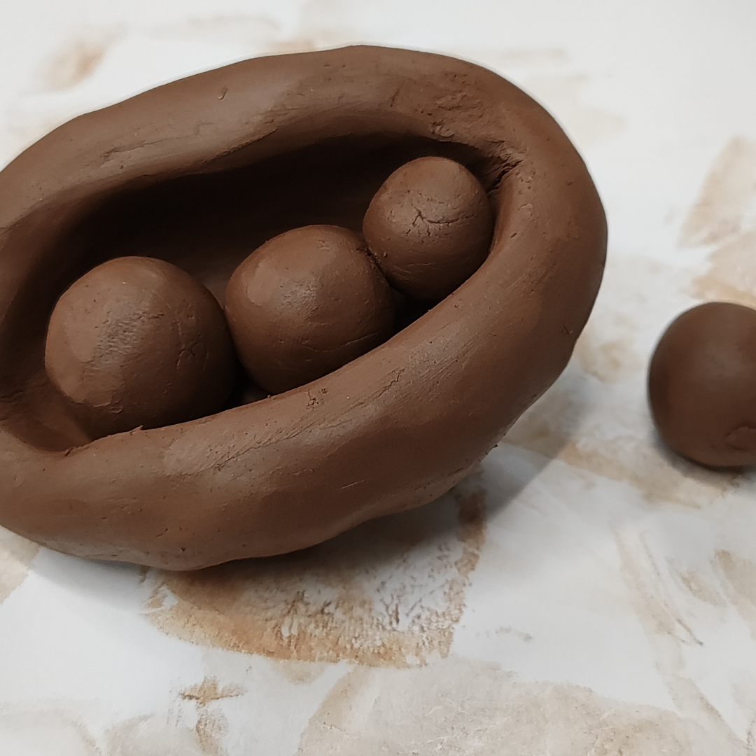 Moulded clay sculpture of spheres in a pod shape