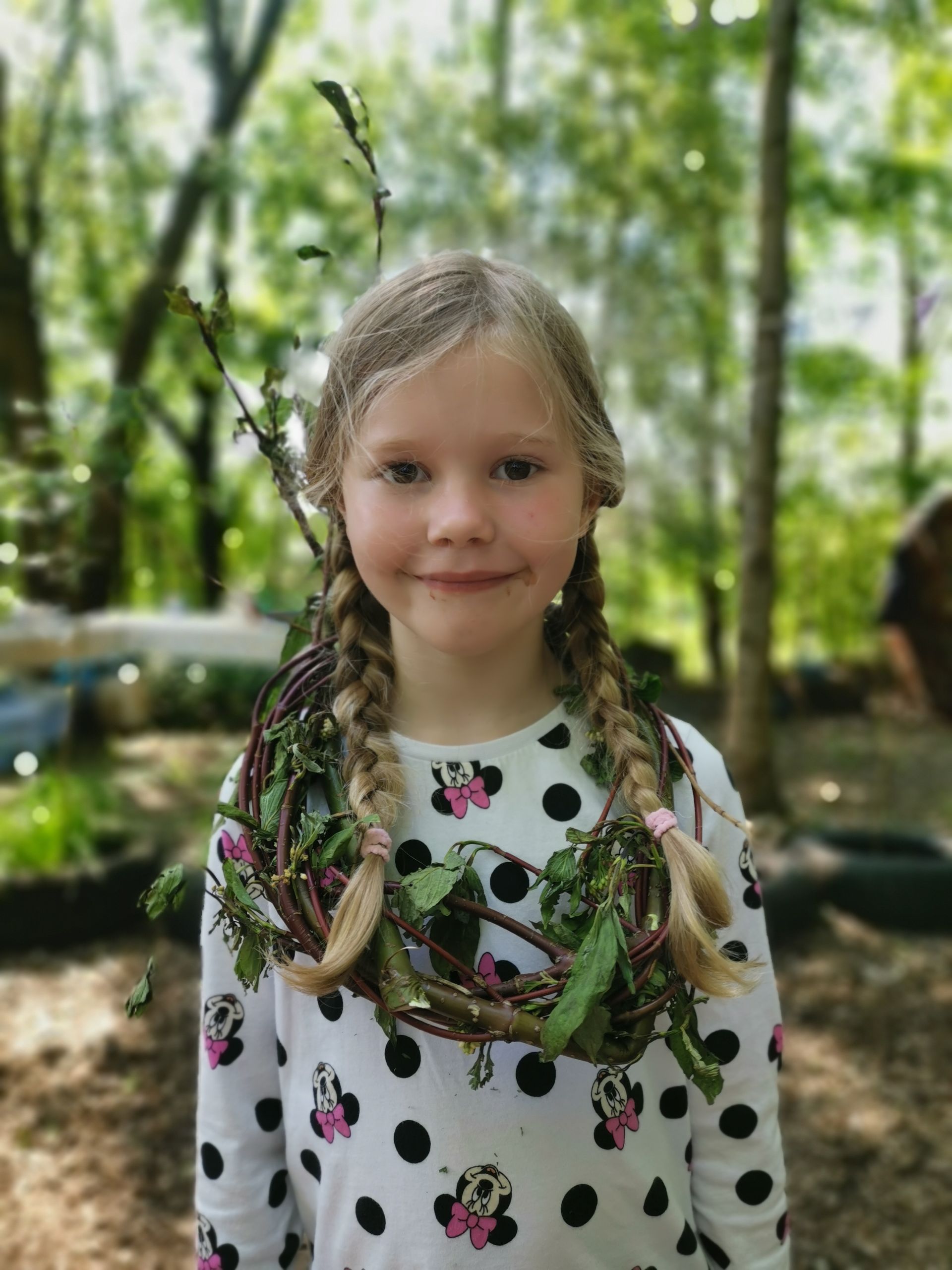 Child with wreath made out of dogwood and leaves at Communitree holiday club