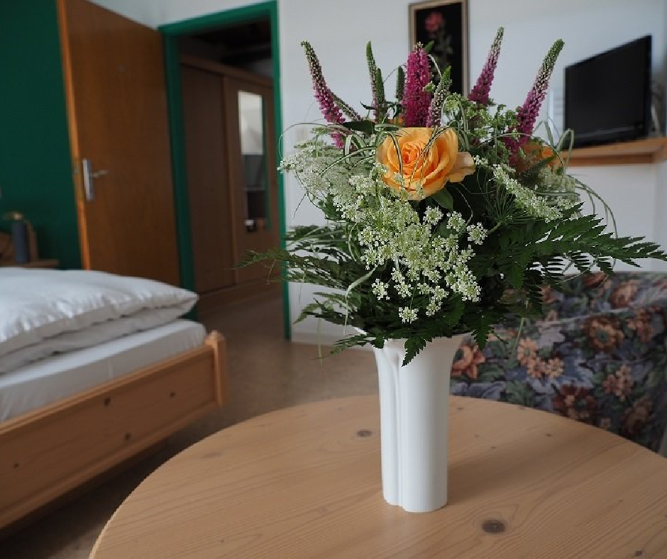 Eines von drei modernen Schlafzimmern der Ferienwohnung im Naturpark mit hellem Design und Blick ins Grüne.