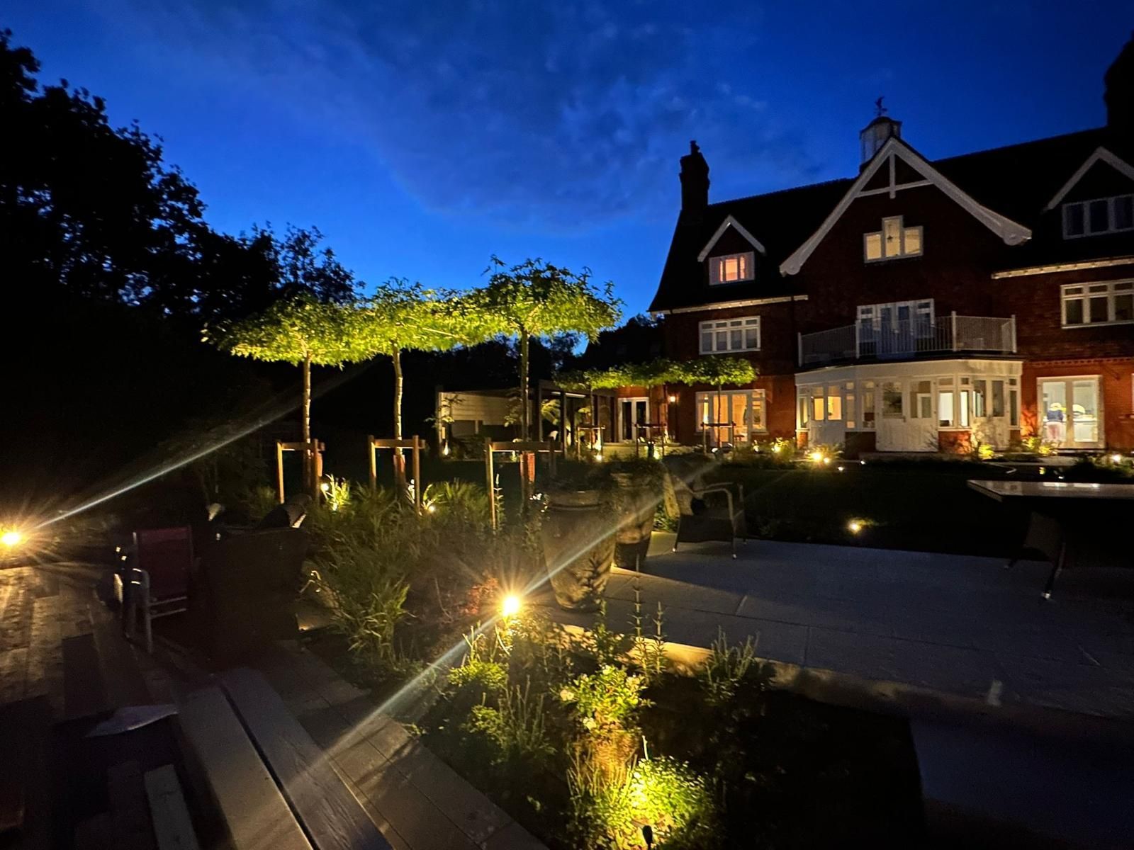 Garden lighting at night with lit pathways and steps