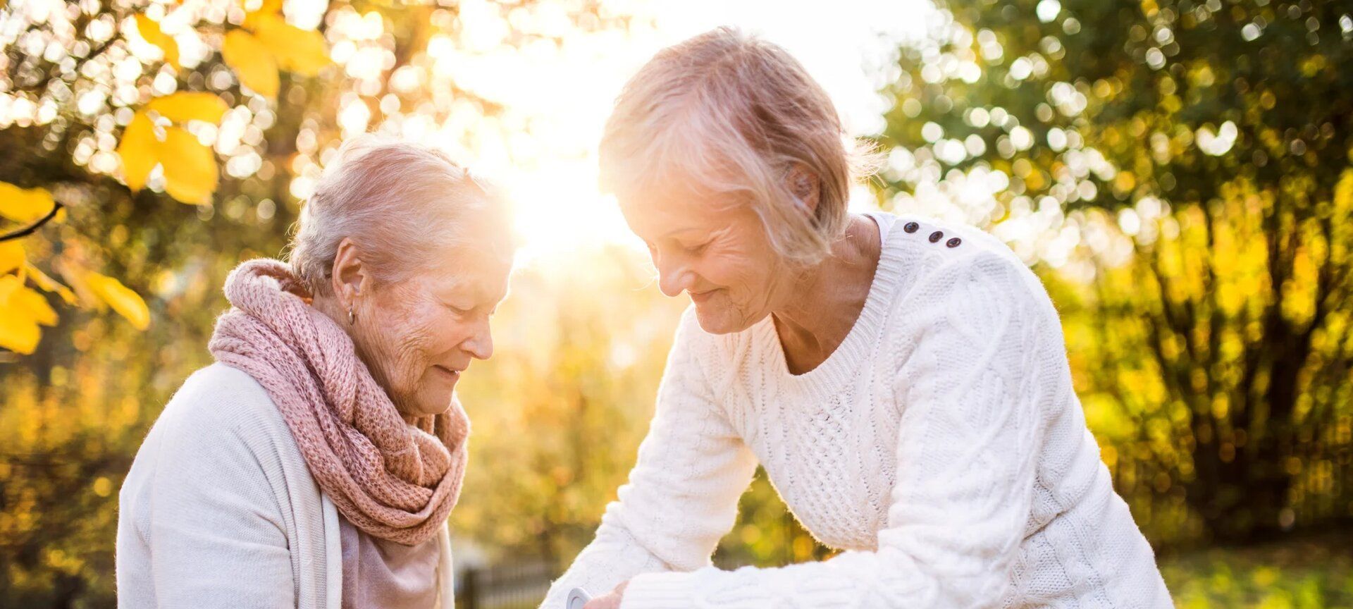 Betreuerin und Senior bei einem Herbstspaziergang im Park