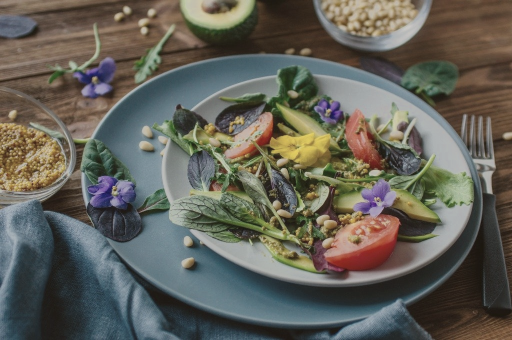 Teller mit Salat und Blüten