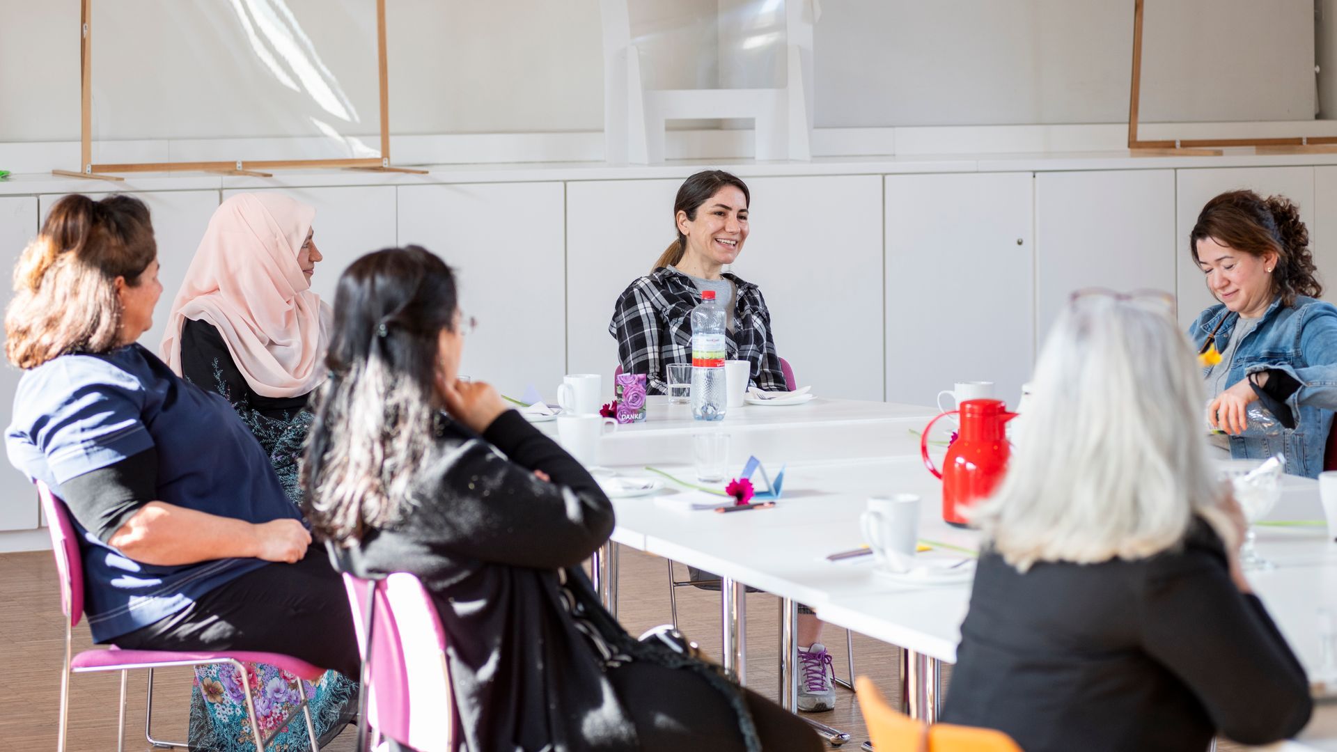 Mehrere Frauen sitzen an einem Tisch und reden.