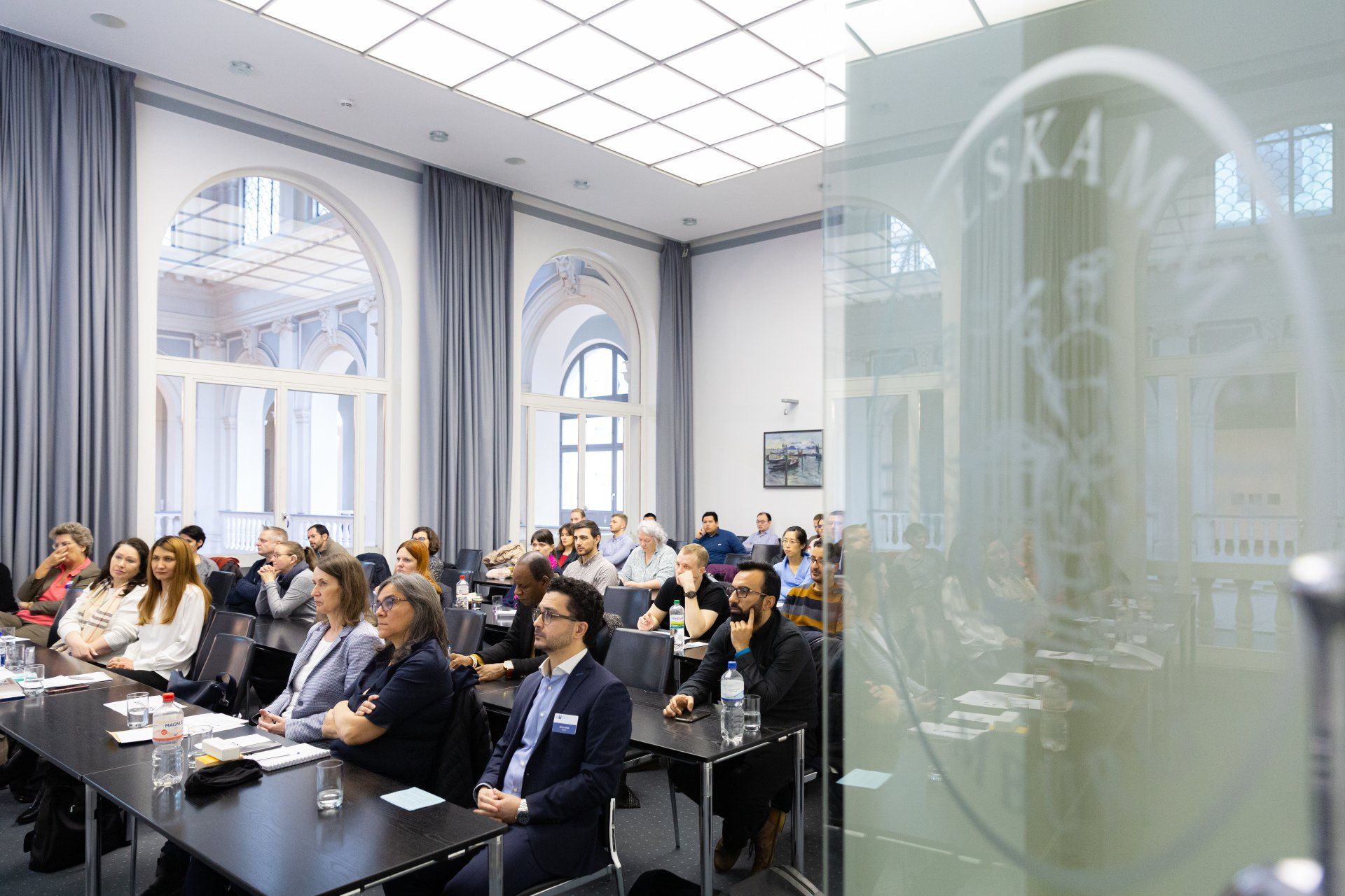 Blick auf die Teilnehmenden durch die geöffnete Tür im Veranstaltungsraum