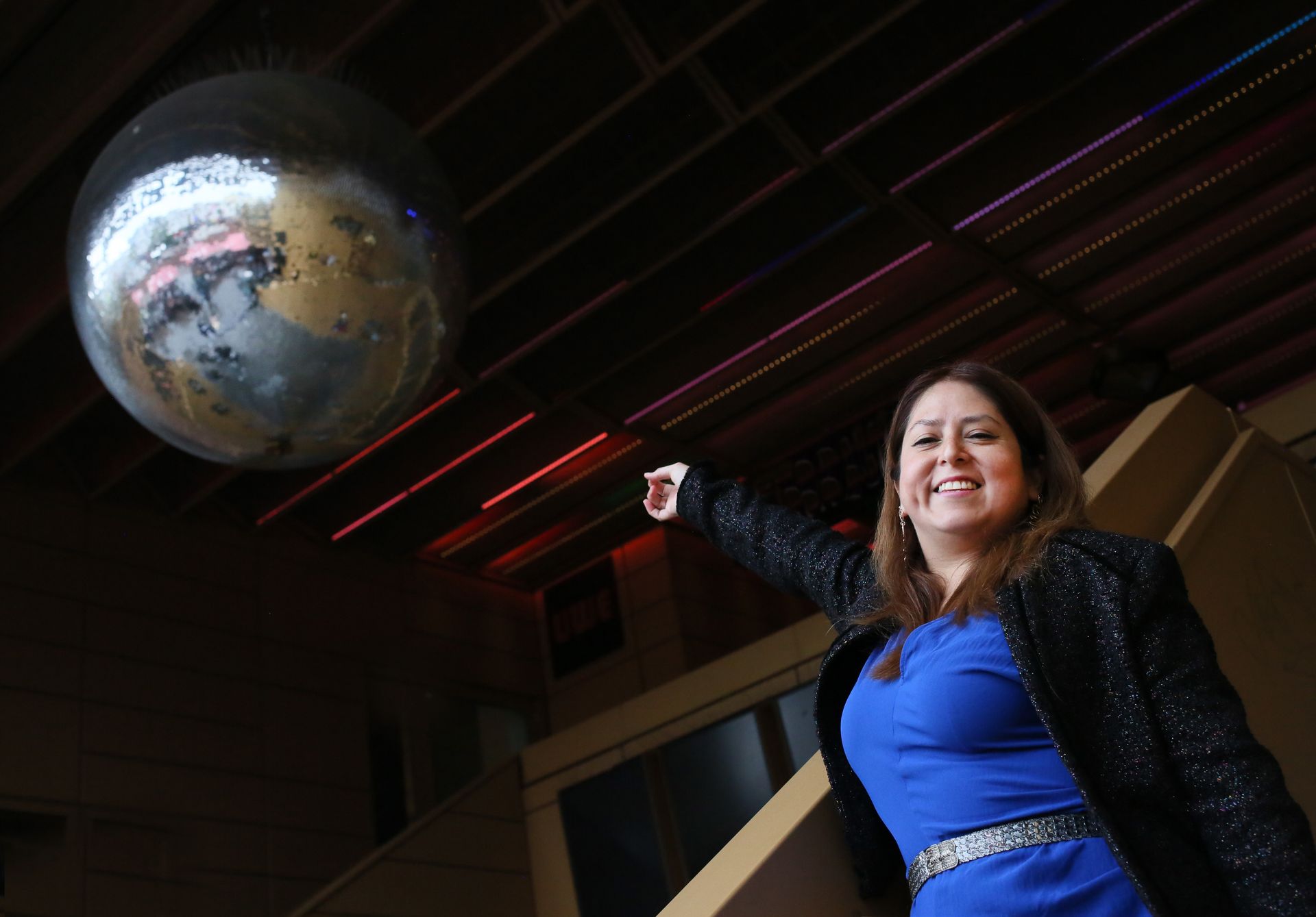 Frau steht neben Diskokugel