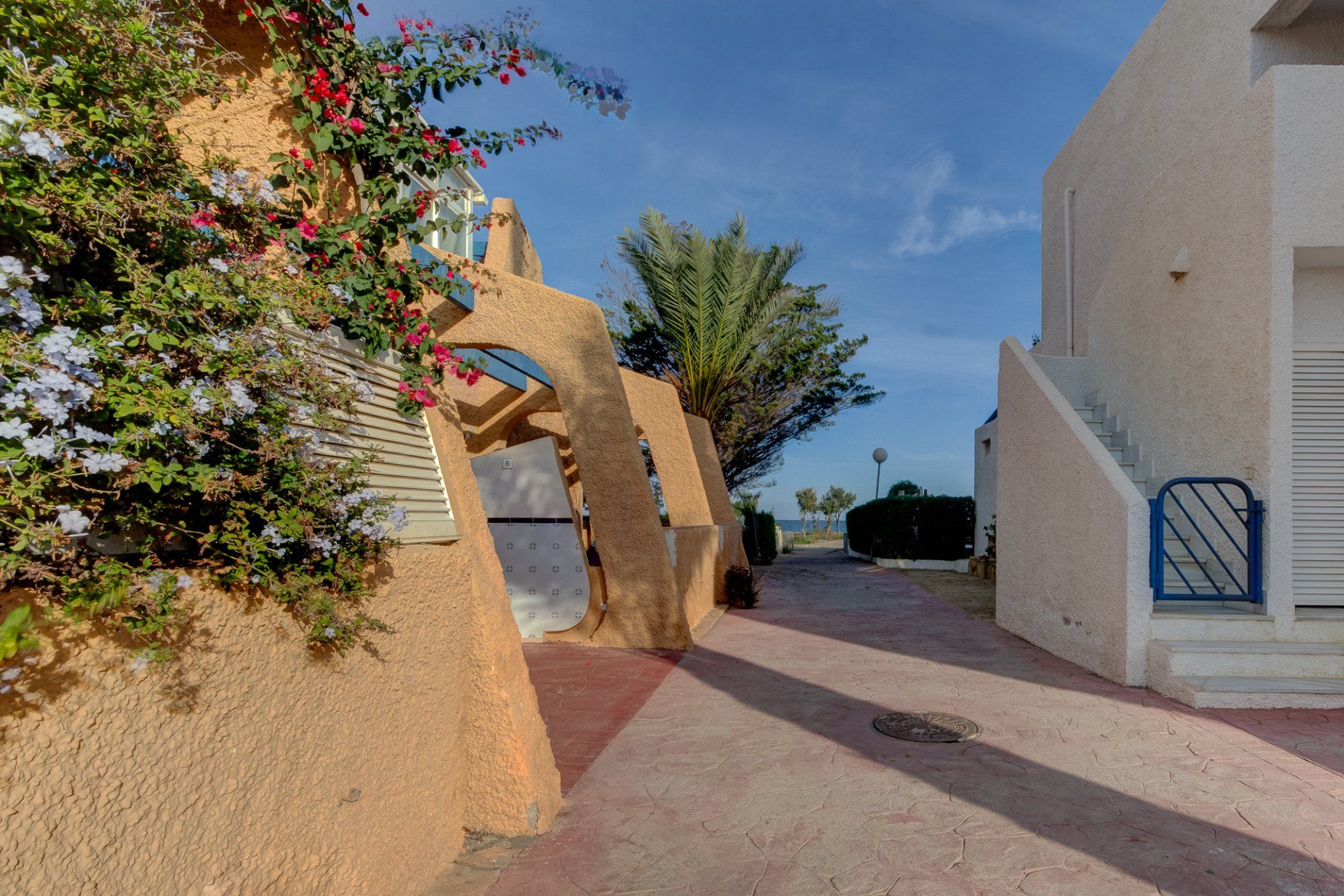 outside the apartment building with the entrance to the left and the path onto the naturist beach straight ahead