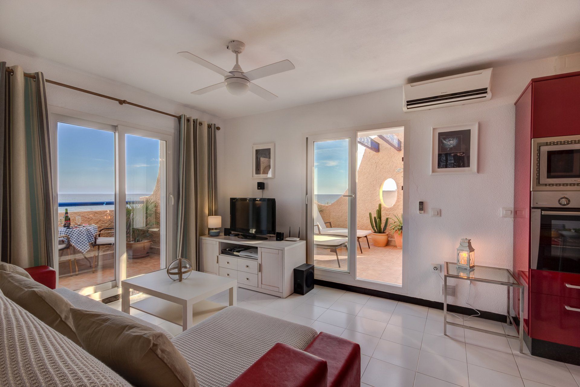 modern and stylish lounge in white and red theme with two patio doors onto the terraces and sea views