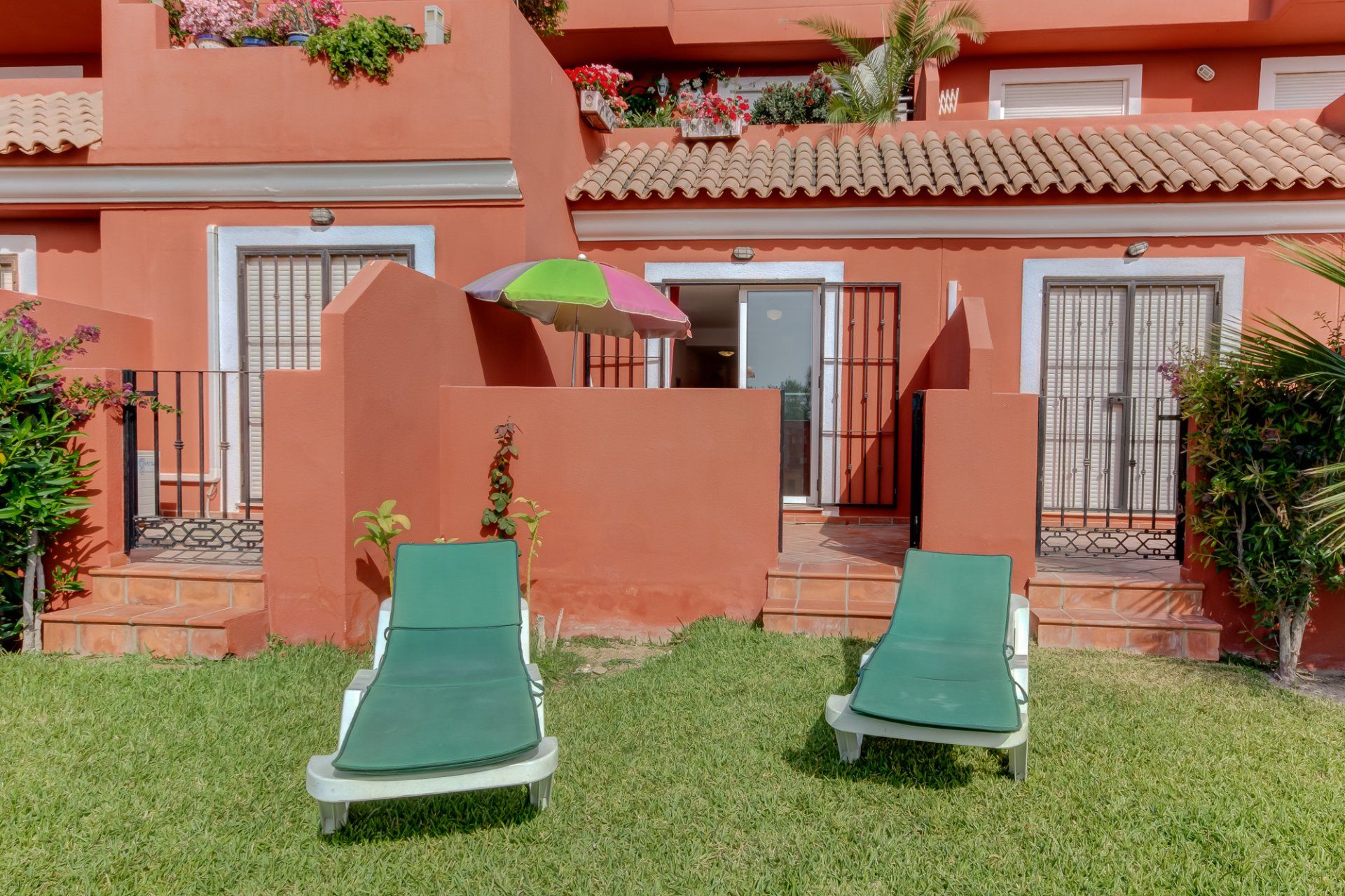 two sunloungers with apartment behind