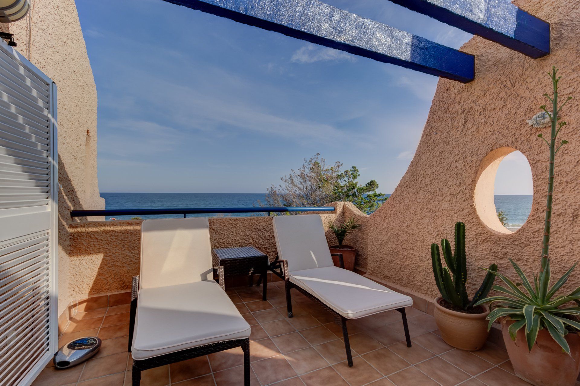 private terrace with two sun loungers and a view of the sea behind