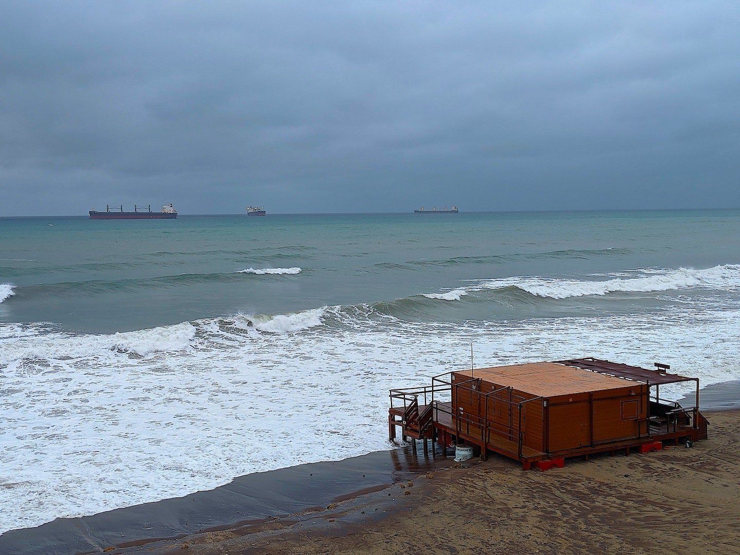 the sea envelops the beach bar during a storm