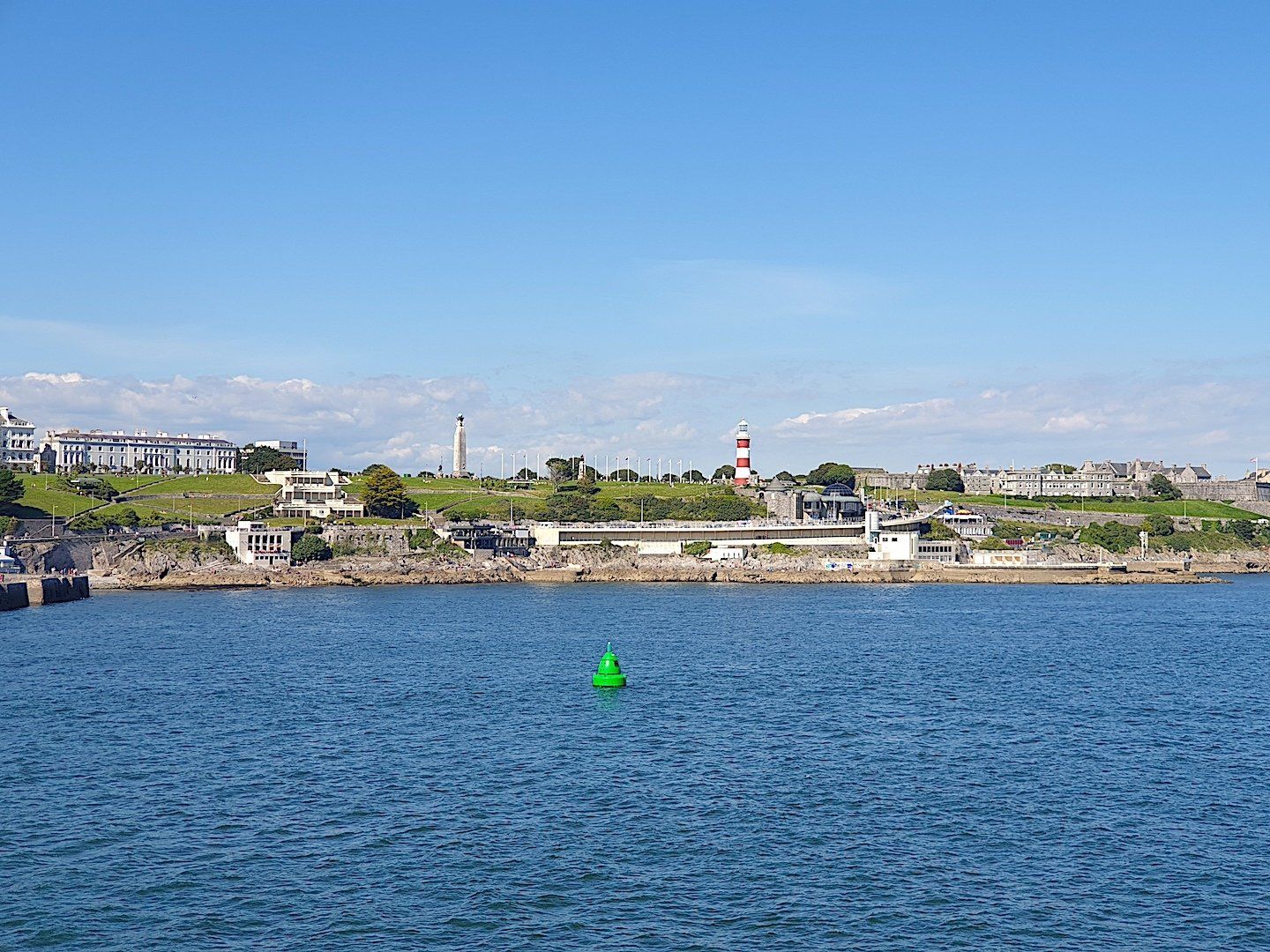 taken from a boat and looking back at the urbanised shoreline with some victorian buildings in the background looking onto green open space