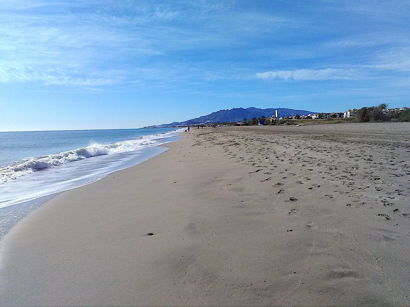 a quiet beach but the soft sand on the shoreline and mild water look so inviting