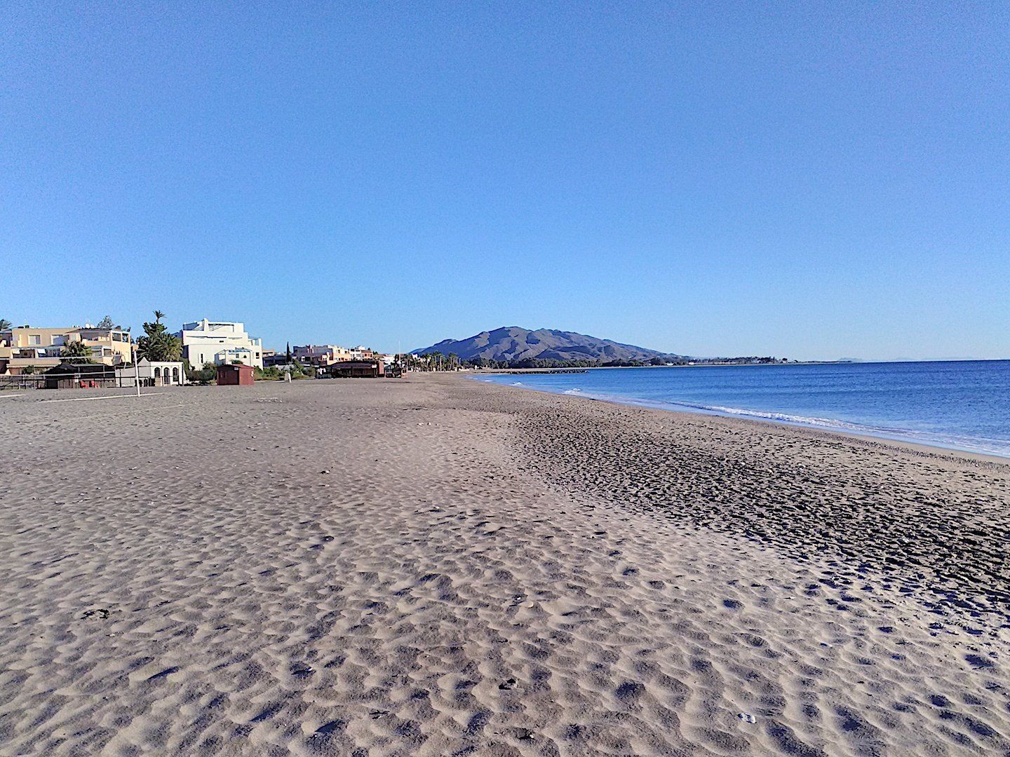 a huge wide expanse of sandy beach with footprints all over it