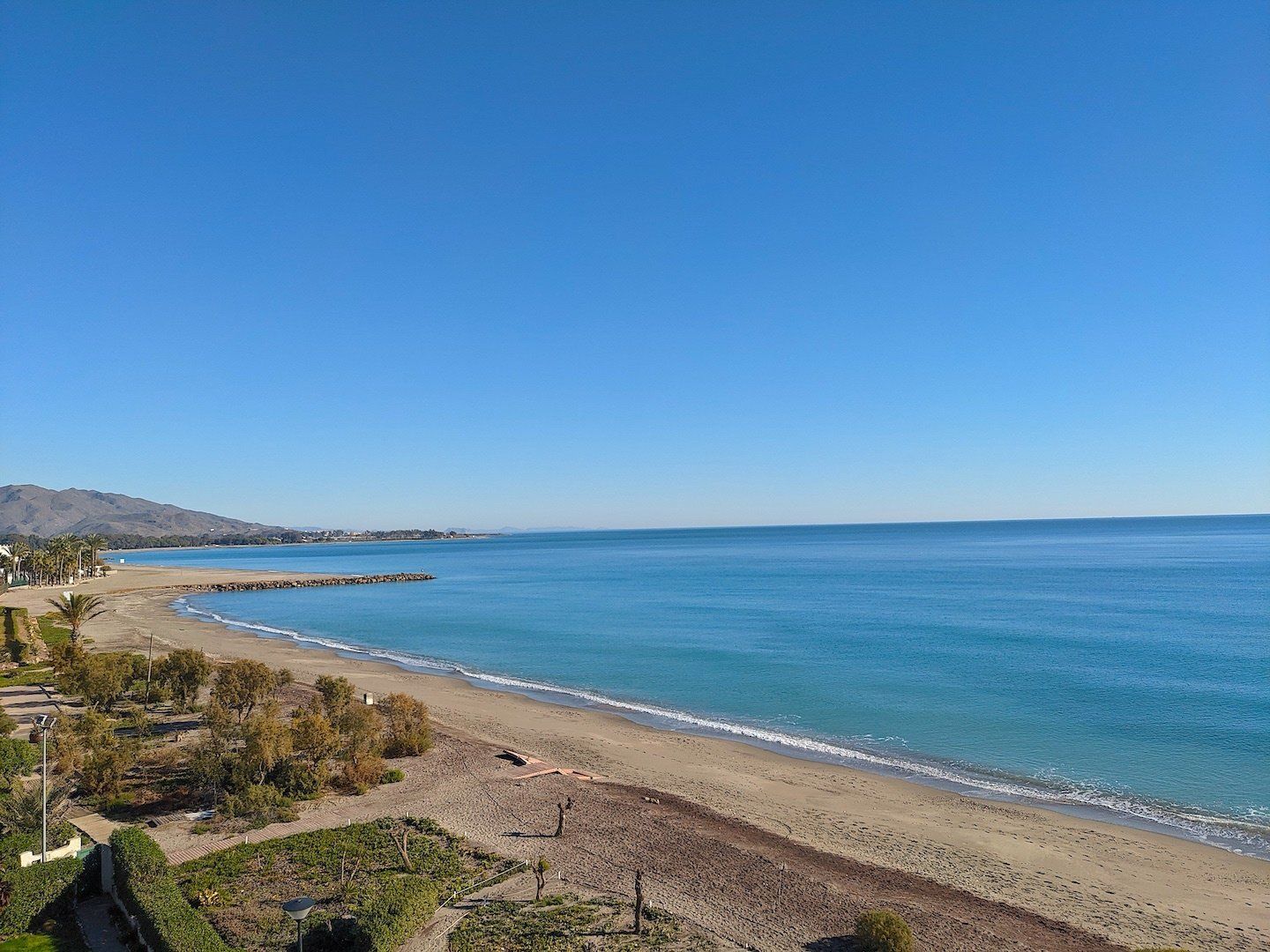 looking north across the beach and the sky is blue and the sea sparkling