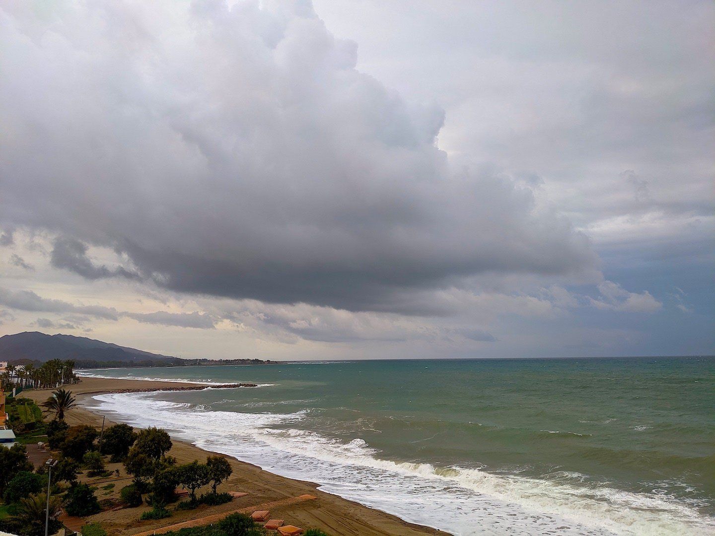 looking out to sea with the water looking dark and stormy while the sky above is grey and looming like a turner painting