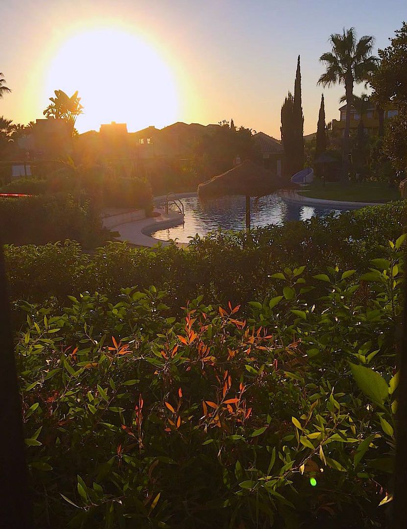 view of the pool as the sun goes down in the distance
