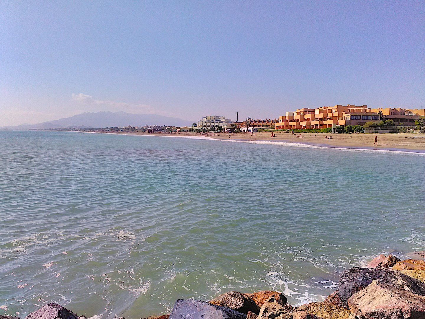 the sweep of the vera playa naturist beach taken from the stone groin looking over the water