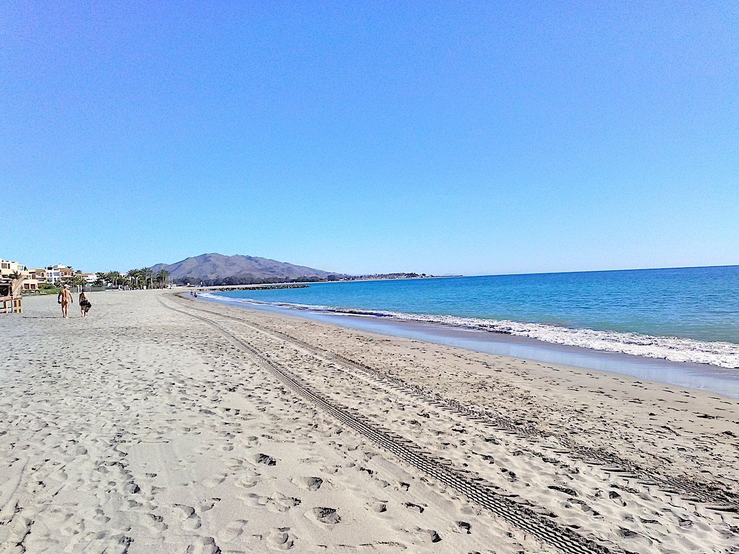 lovely white powdery looking sand stretches ahead with a mountain in the distance