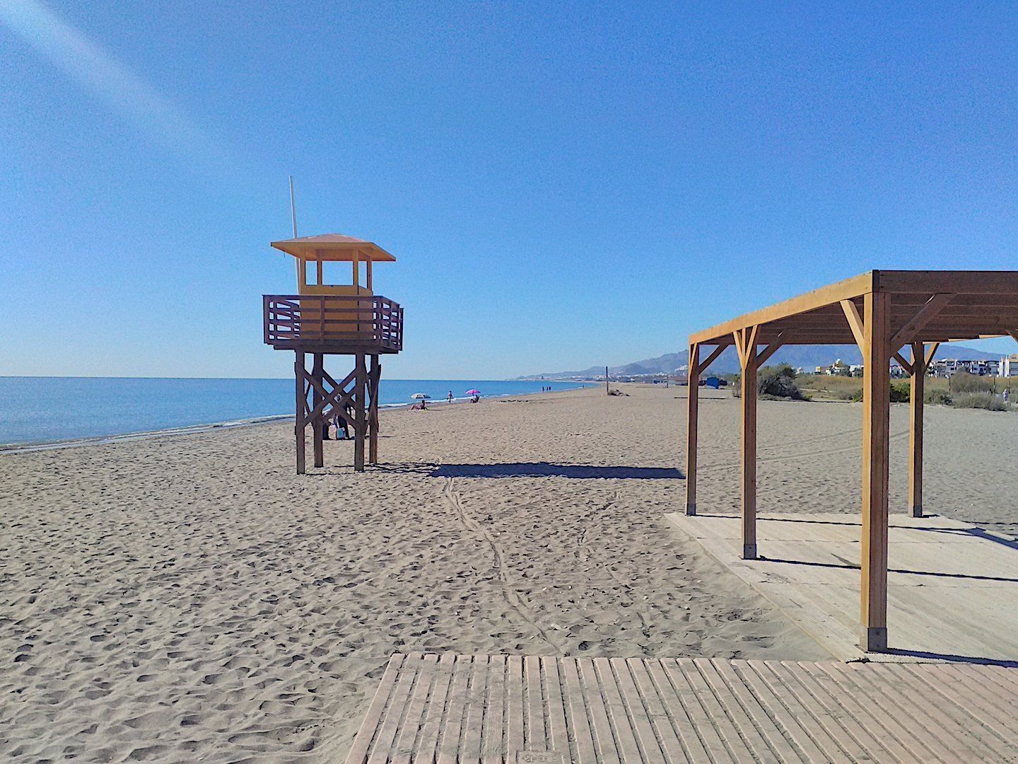 an empty beach before the crowds arrive with the lifeguard tower standing centre stage