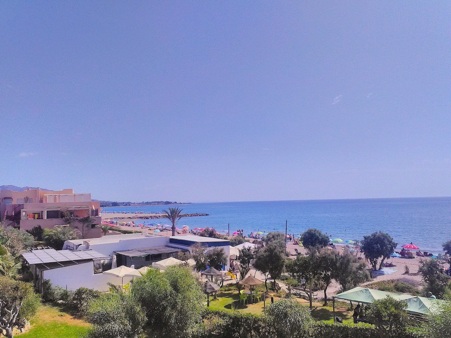 looking out across the beach and out to sea on a hot day with clear blue skies