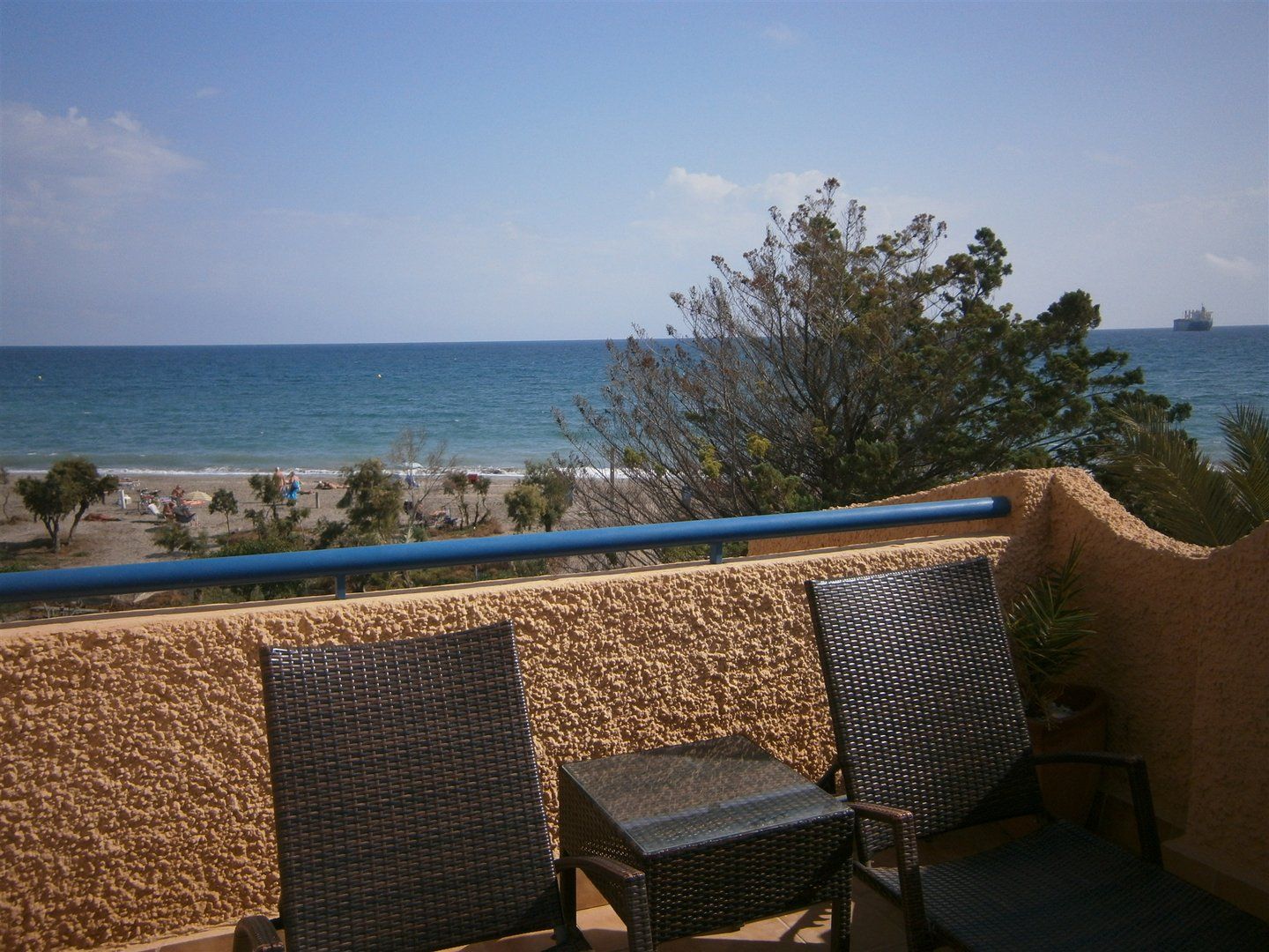 the tops of two sunloungers on the main terrace looking over the wall at the naturist beach below