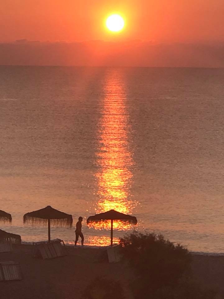 sun rise over the playa shining across the sea and the sun loungers