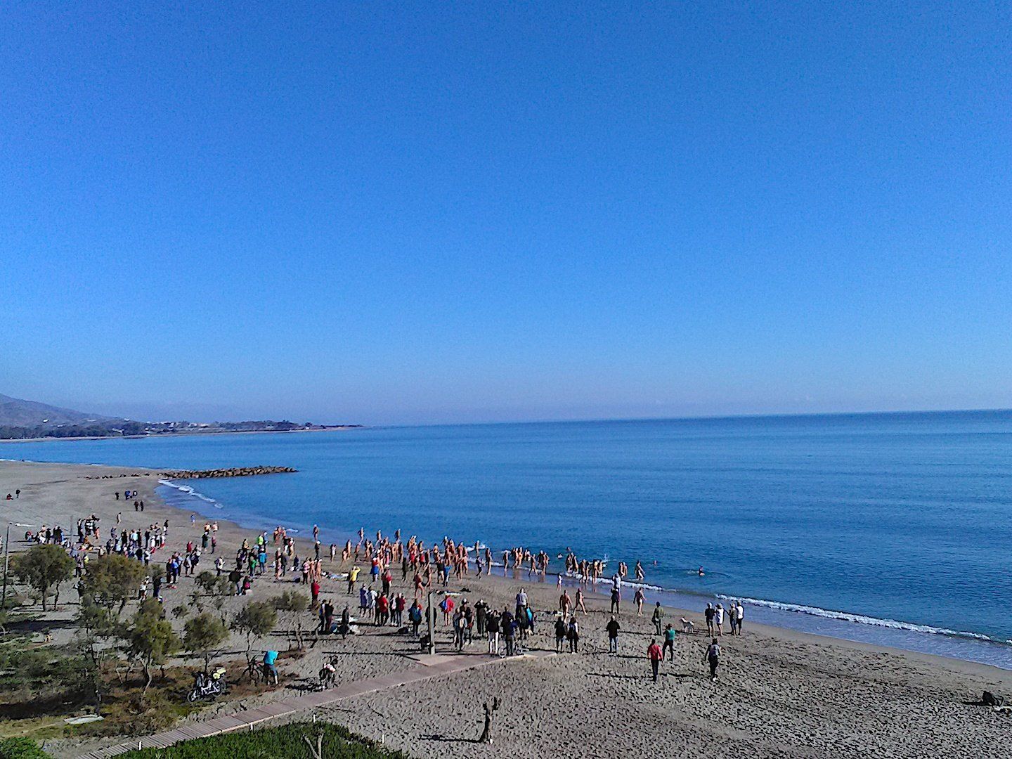 taken from afar of a small crowd gathering on the beach
