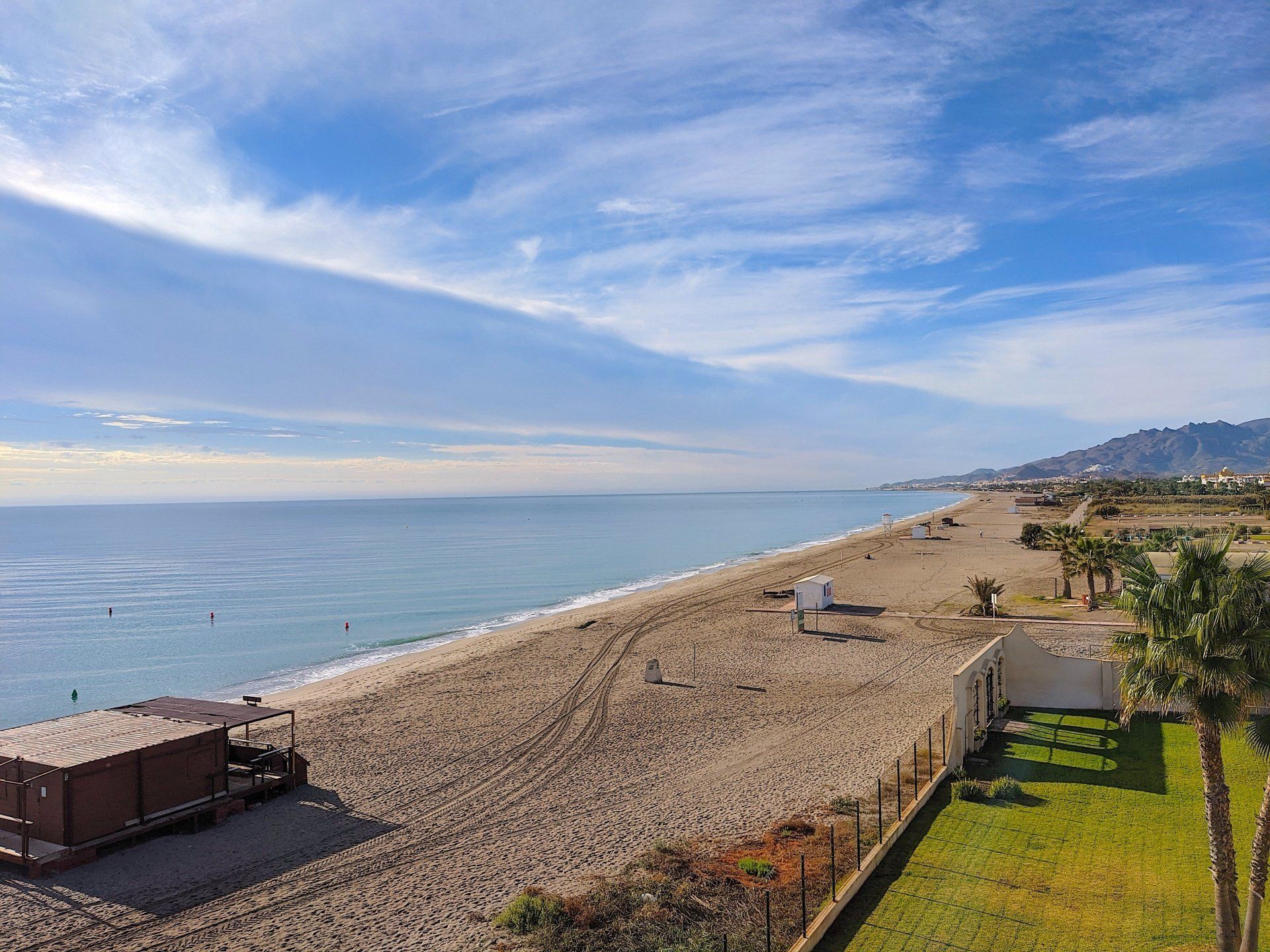 looking down onto a long sandy beach stretching south