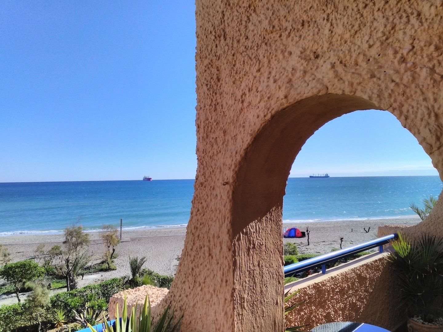looking through an from the terrace archway and the beach and sea view beyond