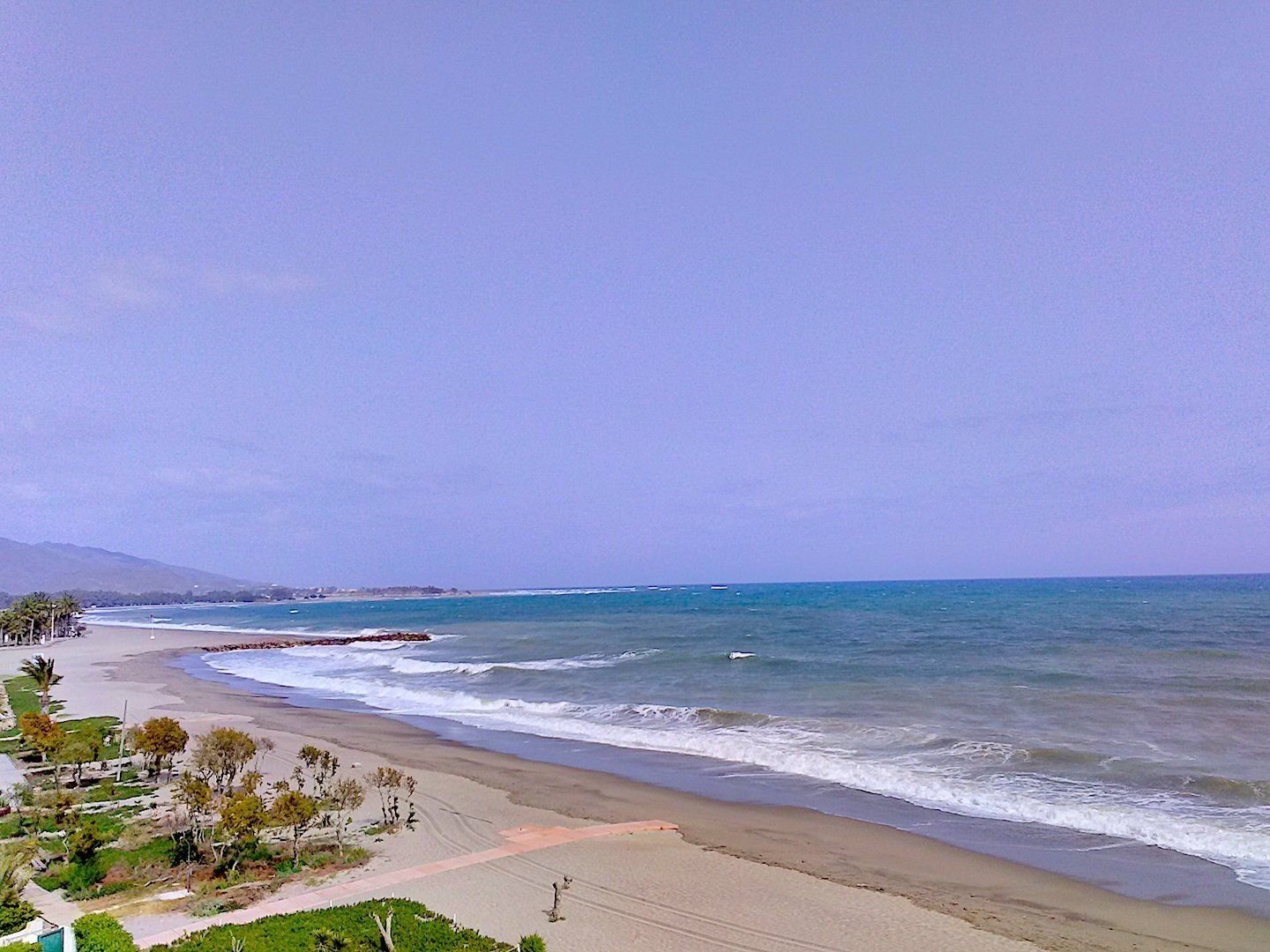 view from above of the naturist beach looking north with high seas and not a soul in sight