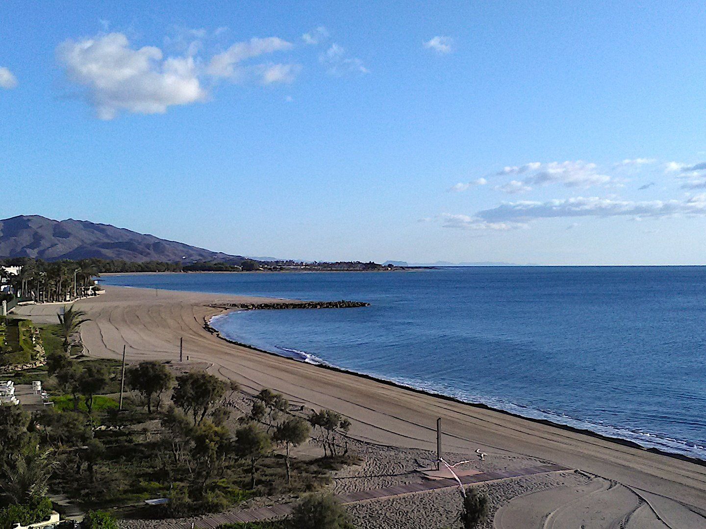 looking northwards across the beach and sea with mountain at the far end