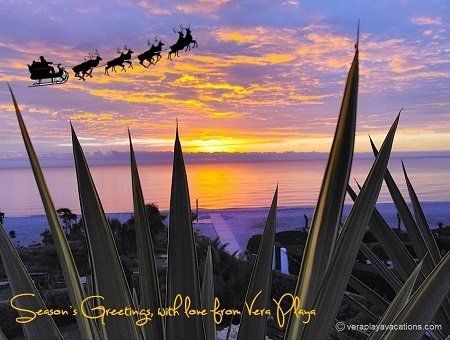 christmas card of view from terrace looking over vera playa beach in golden purple colours and santa and his sleigh flying high in the sky