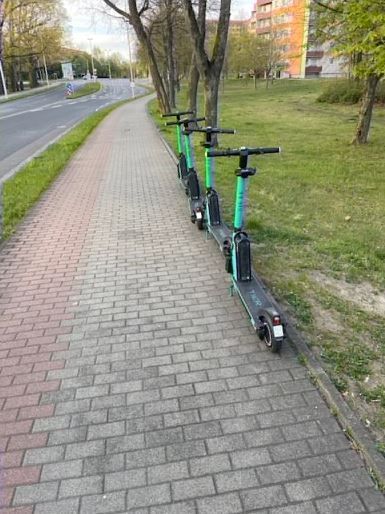 E-Scooter stehen auf einem Gehweg