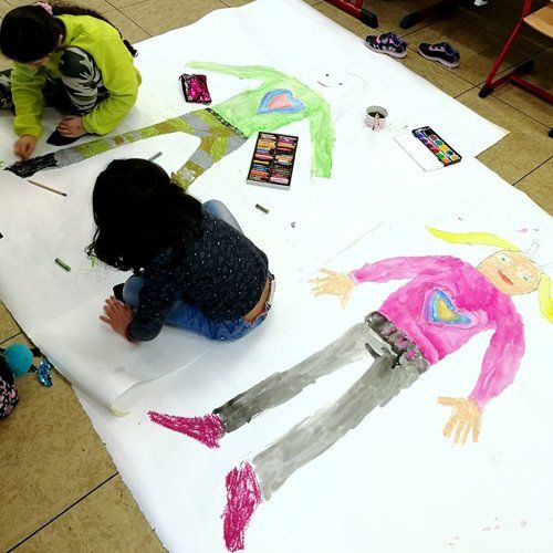 Kinder malen lebensgroße Figuren