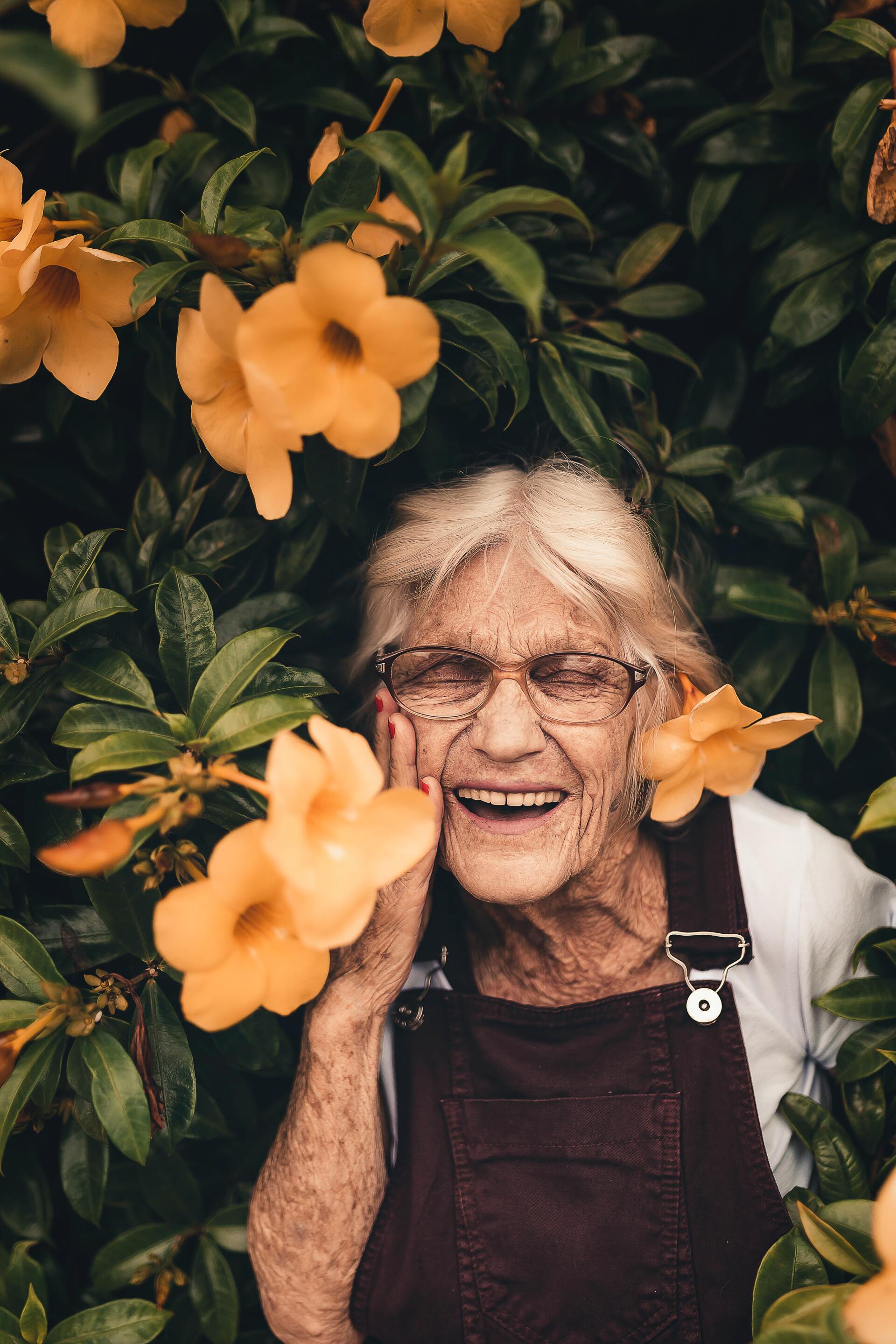 Alte Frau zwischen Blüten