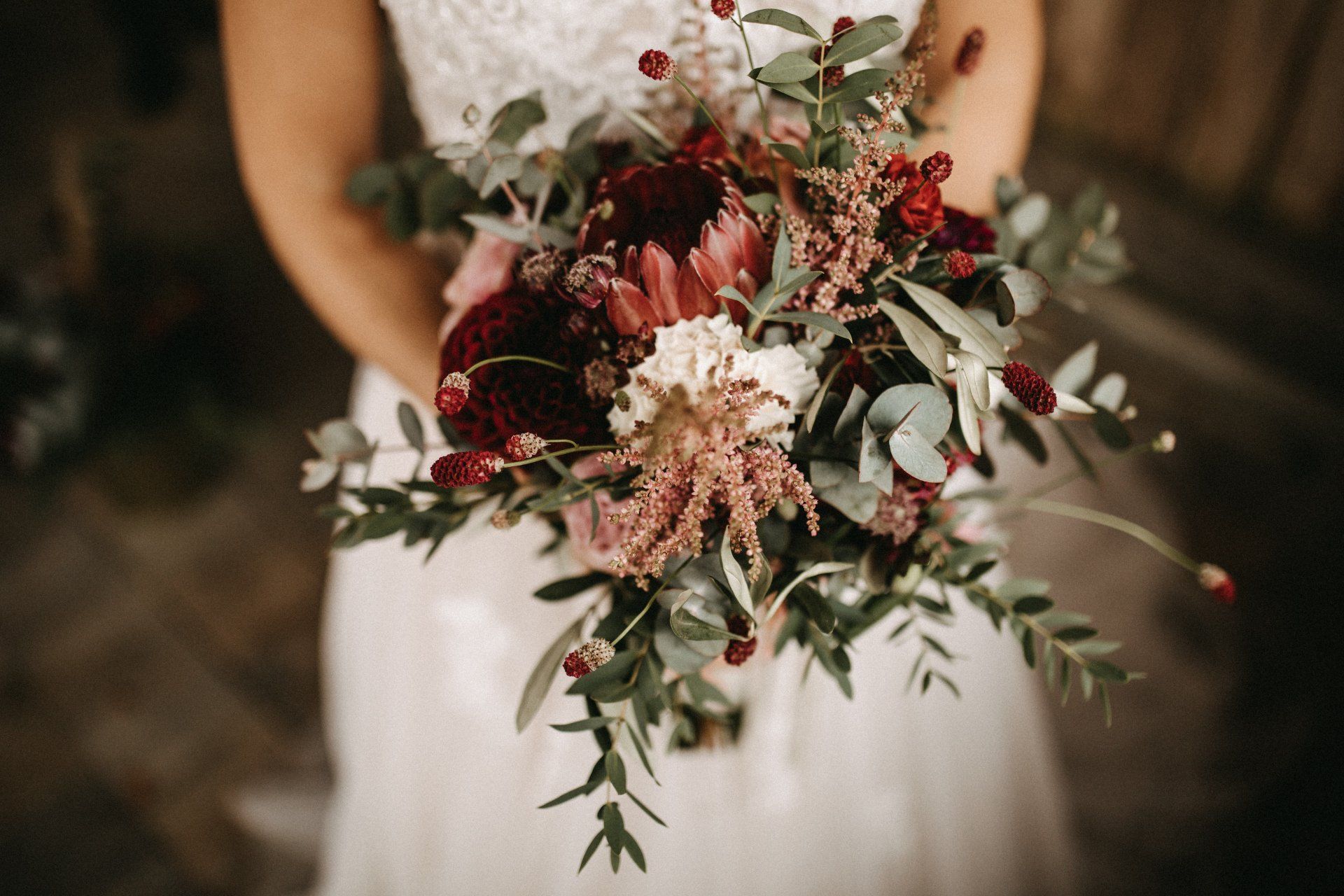 Alle Fragen rund um Eure Hochzeitsfloristik. Brautstrauß im wilden Boho Style in den Fraben rot und rosa mit Olive und Eukalyptus