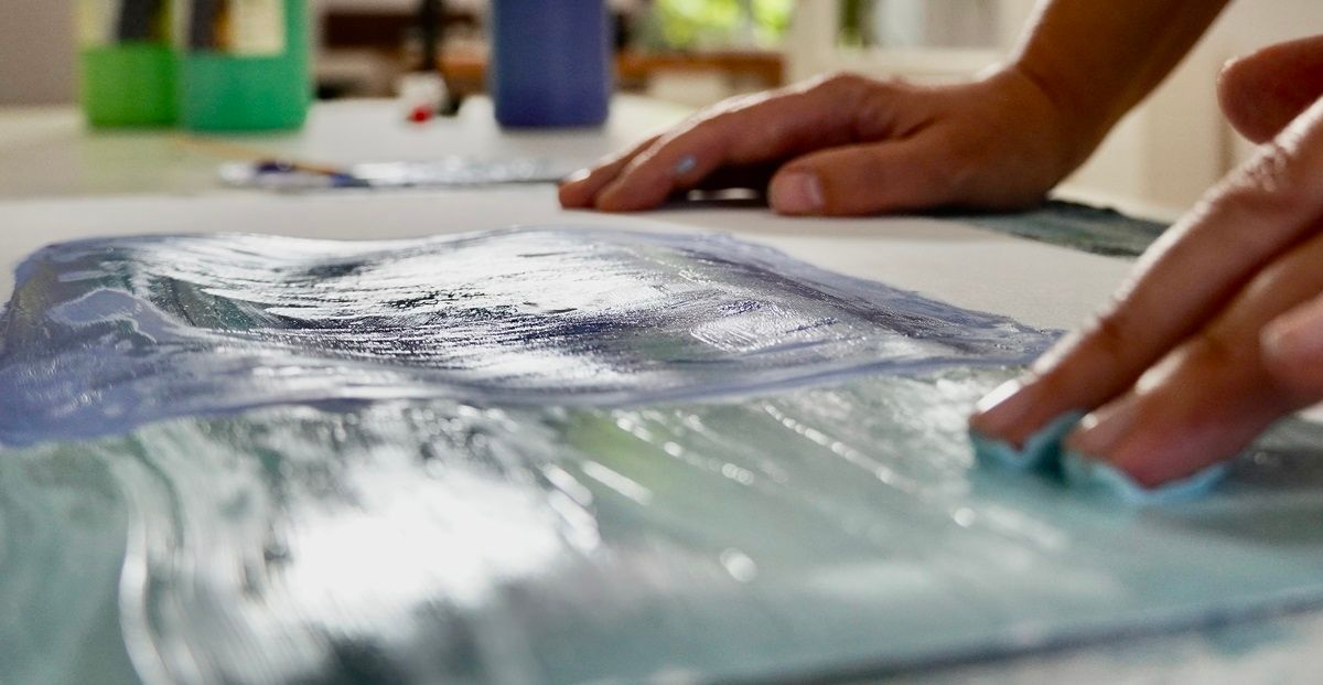 Zwei Hände, die an einem Bild malen, die noch nasse Farbe ist sichtbar - Praxis für Kunsttherapie Susanne Grön in Zarrentin.