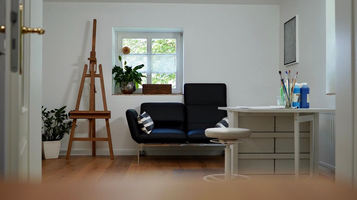 Blick auf Sofa, Staffelei und Malutensilien - Praxis für Kunsttherapie Susanne Grön in Zarrentin.