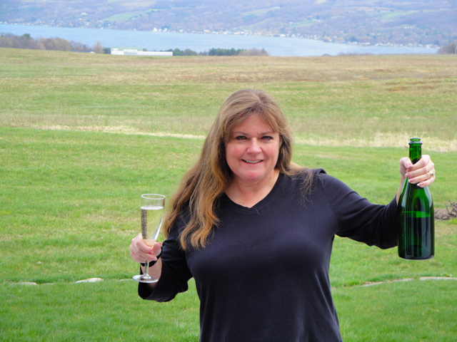 Gal holding Azure Hill Sparkling Riesling Wine and glass outside