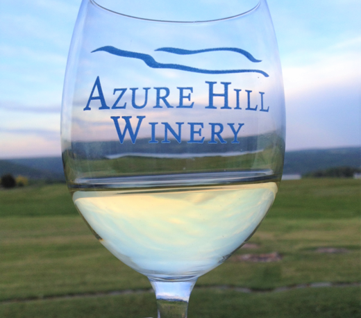 Glass of white Riesling wine with azure hill winery logo on the glass.