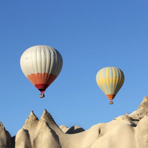 Zwei Heißluftballons am blauen Himmel über Bergen symbolisieren Teilnahme an MBSR