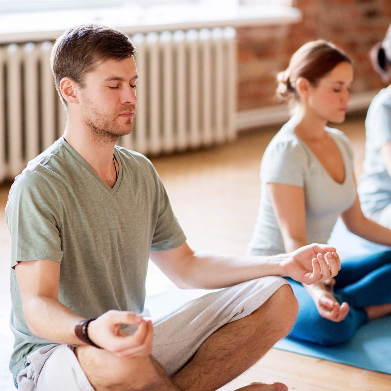 Ein Mann und eine Frau meditieren sitzend auf einer Yogamatte
