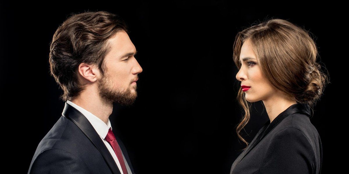 une homme et une femme en costume qui se regarde avec un air intérrogatif