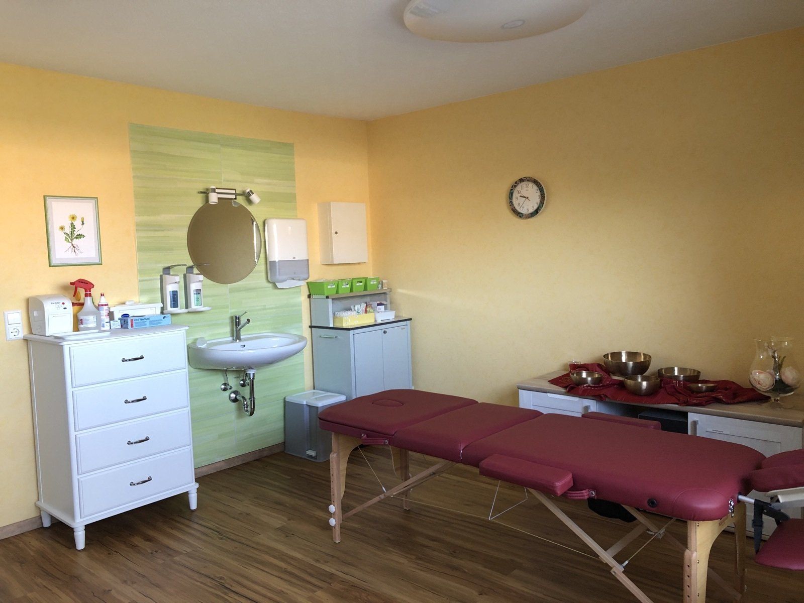 Behandlungsbereich Praxisraum innen, Behandlungsbereich mit Liege, Schränken und Waschbecken