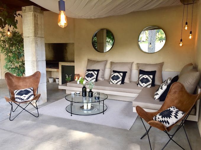 Coussins extérieurs beiges et noirs sur mesure pour l'aménagement d'un salon maçonné sous un pool house.
