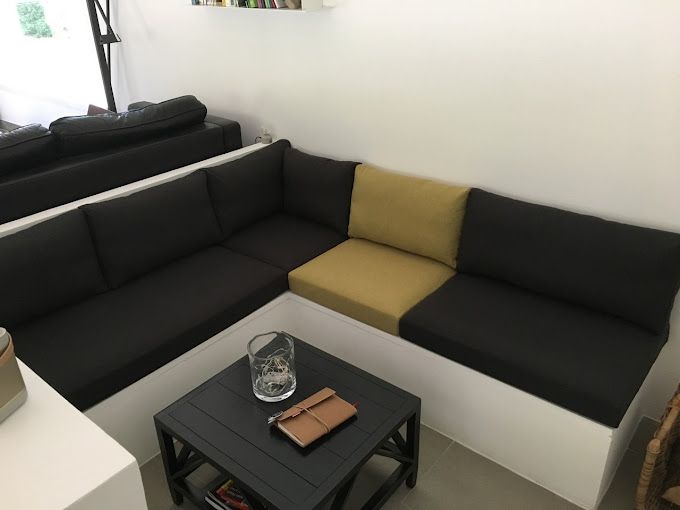 Coussins d'assise et de dossier sur mesure bicolores noirs et jaunes pour un canapé d'angle.