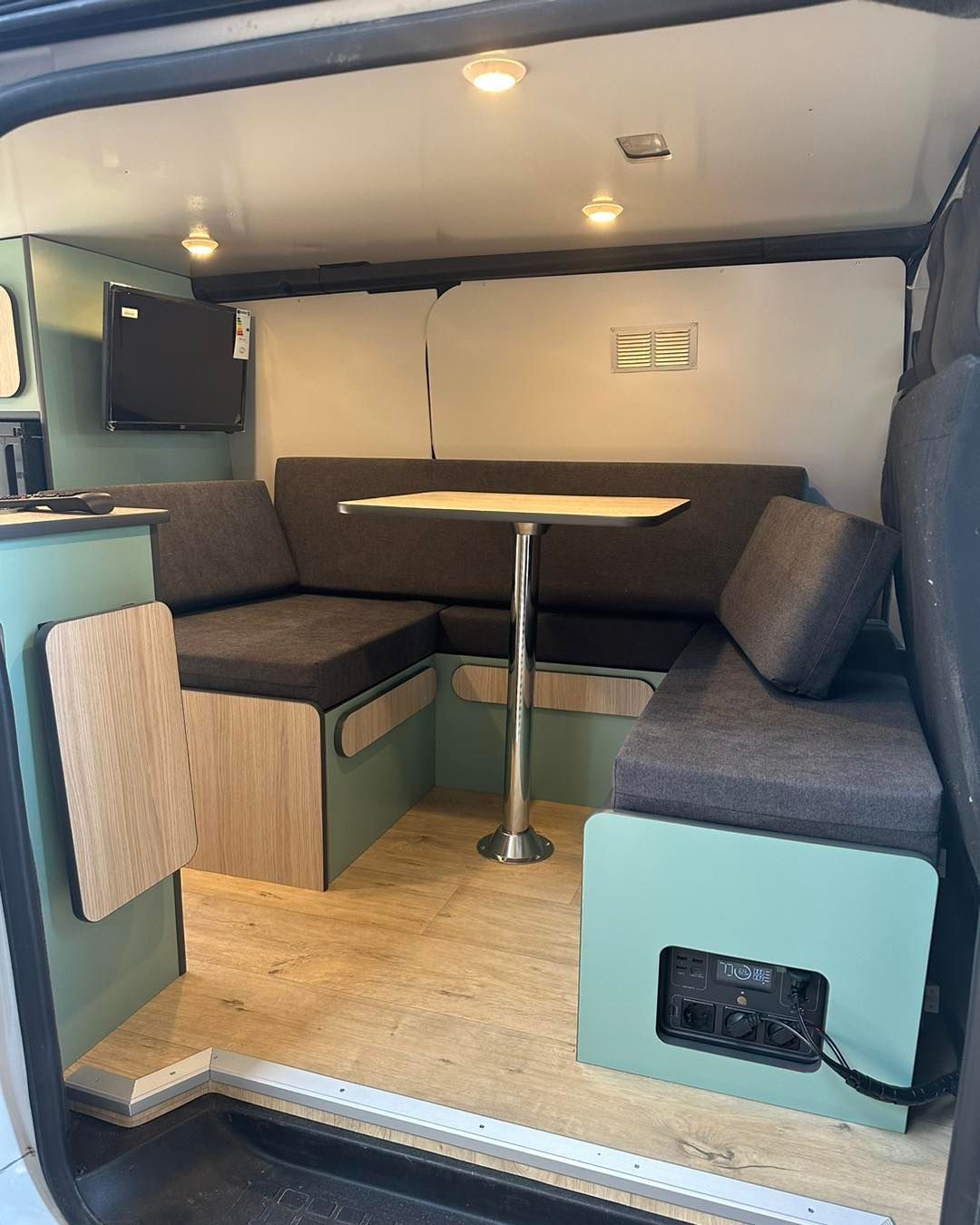 Banquette d'angle sur mesure gris anthracite avec meuble bois dans fourgon aménagé – van life Mousse et Confection