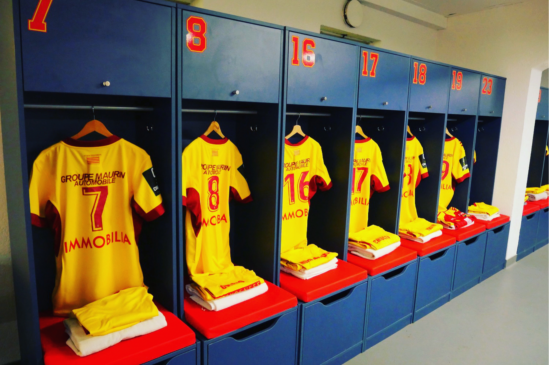 Coussins sur mesure rouges pour les sièges du vestiaire de l'équipe du RC Lens.