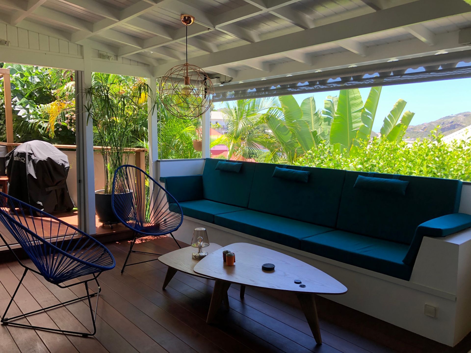 Long coussin d'assise bleu canard sur mesure pour l'aménagement d'une banquette sous une terrasse couverte.